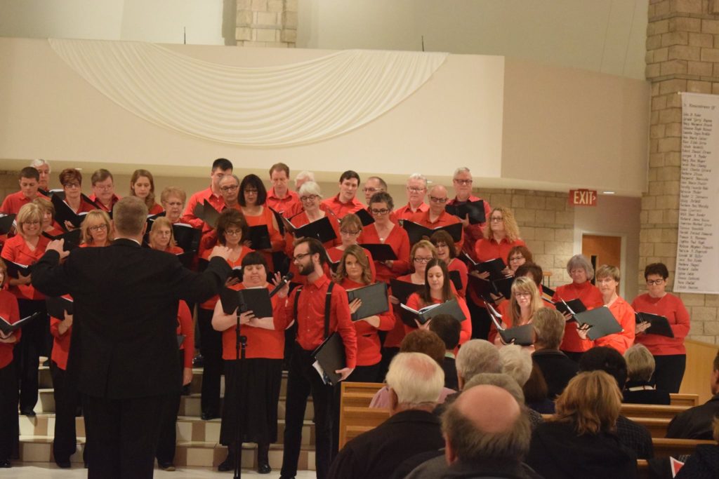 red dressed singers perform a concert